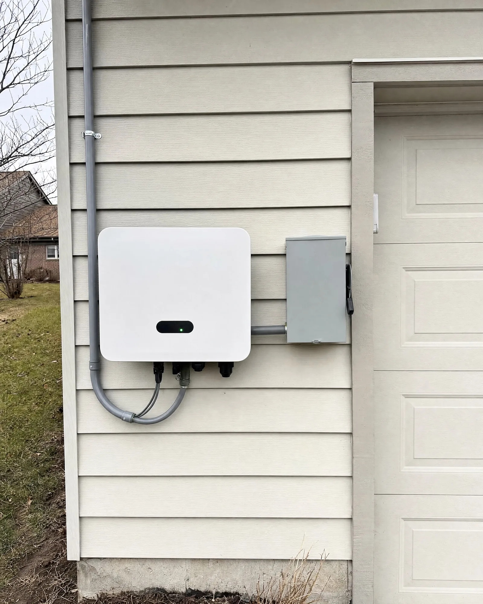 Wall-mounted solar inverter and disconnect on the side of a home